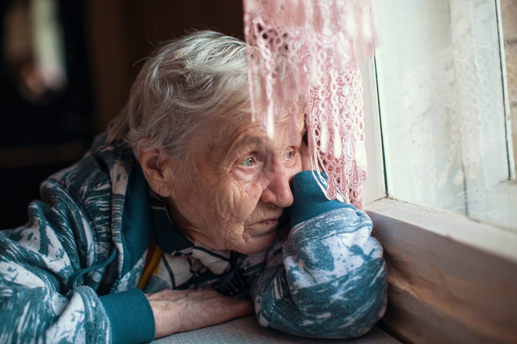 lonely old lady looking out of the window