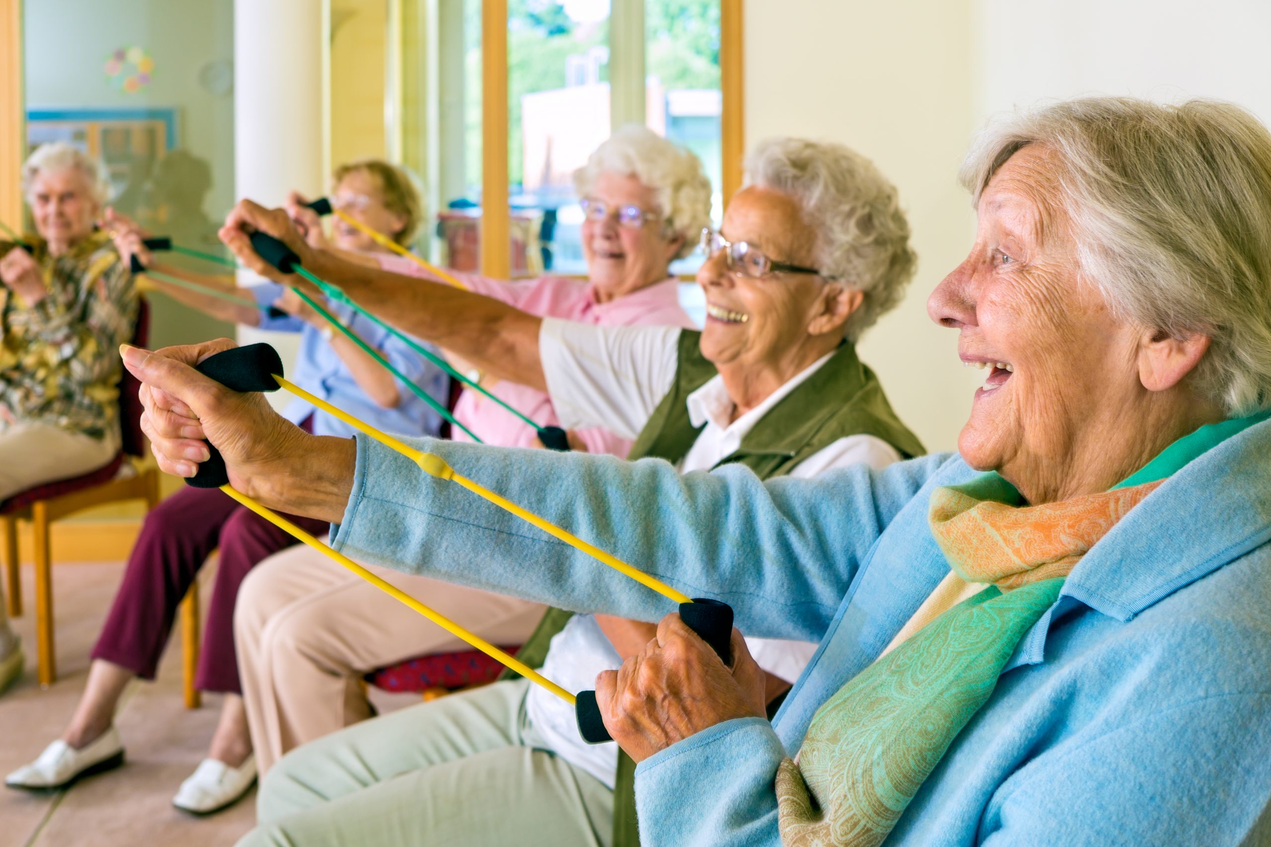 Older adults in seated exercise class using resistance bands for their arms