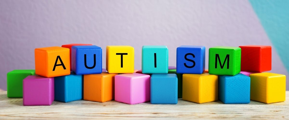 Autism written on coloured building blocks